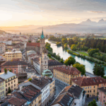 Drohnenaufnahmen Kärnten – historische Altstadt mit Fluss und Bergpanorama im Hintergrund.