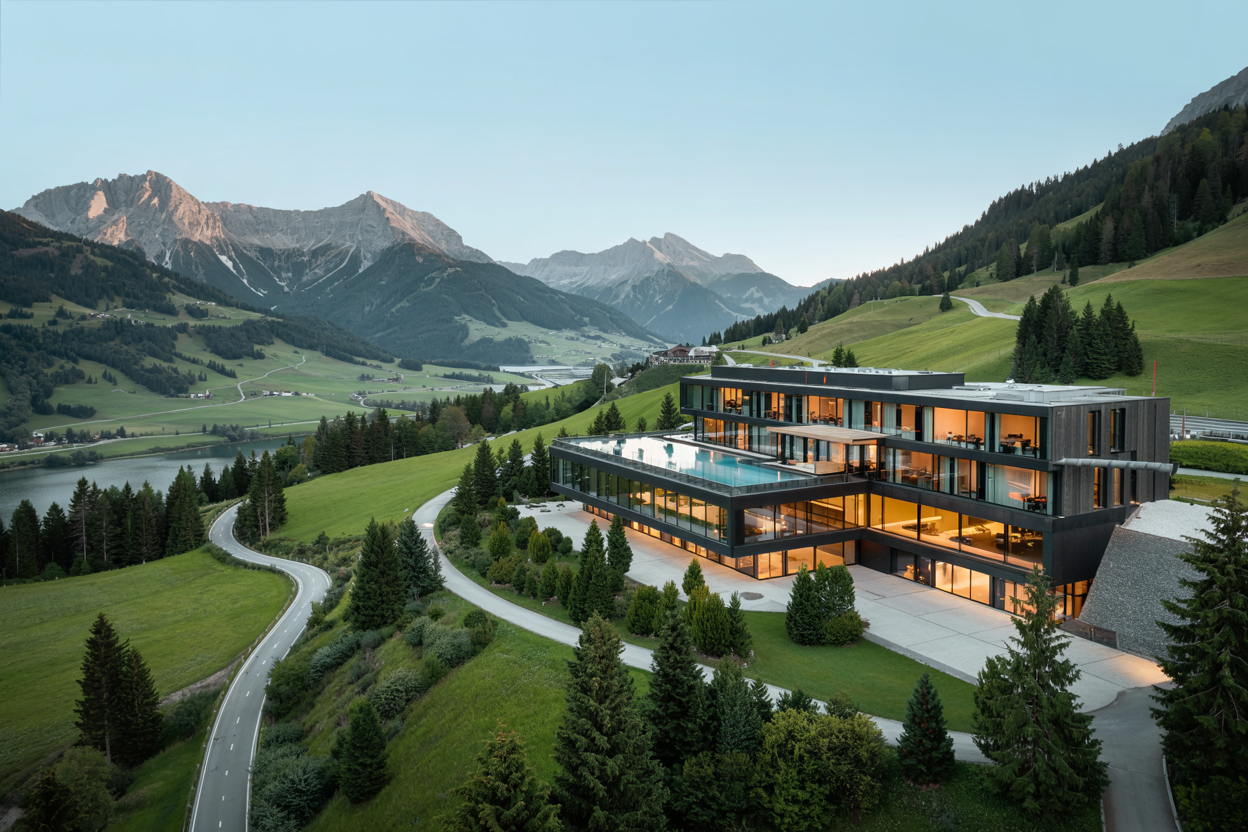 Modernes Hotel in Kärnten mit Panoramablick auf die Alpen und Infinity-Pool inmitten grüner Berglandschaften.